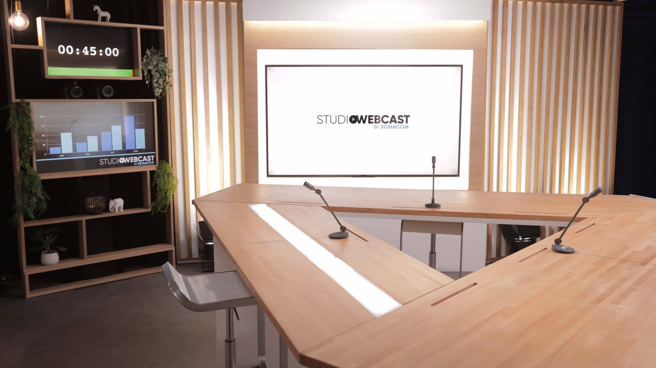 Plateau TV du Studio Webcast avec table en bois, microphones de table et grand écran affichant le logo Studio Webcast