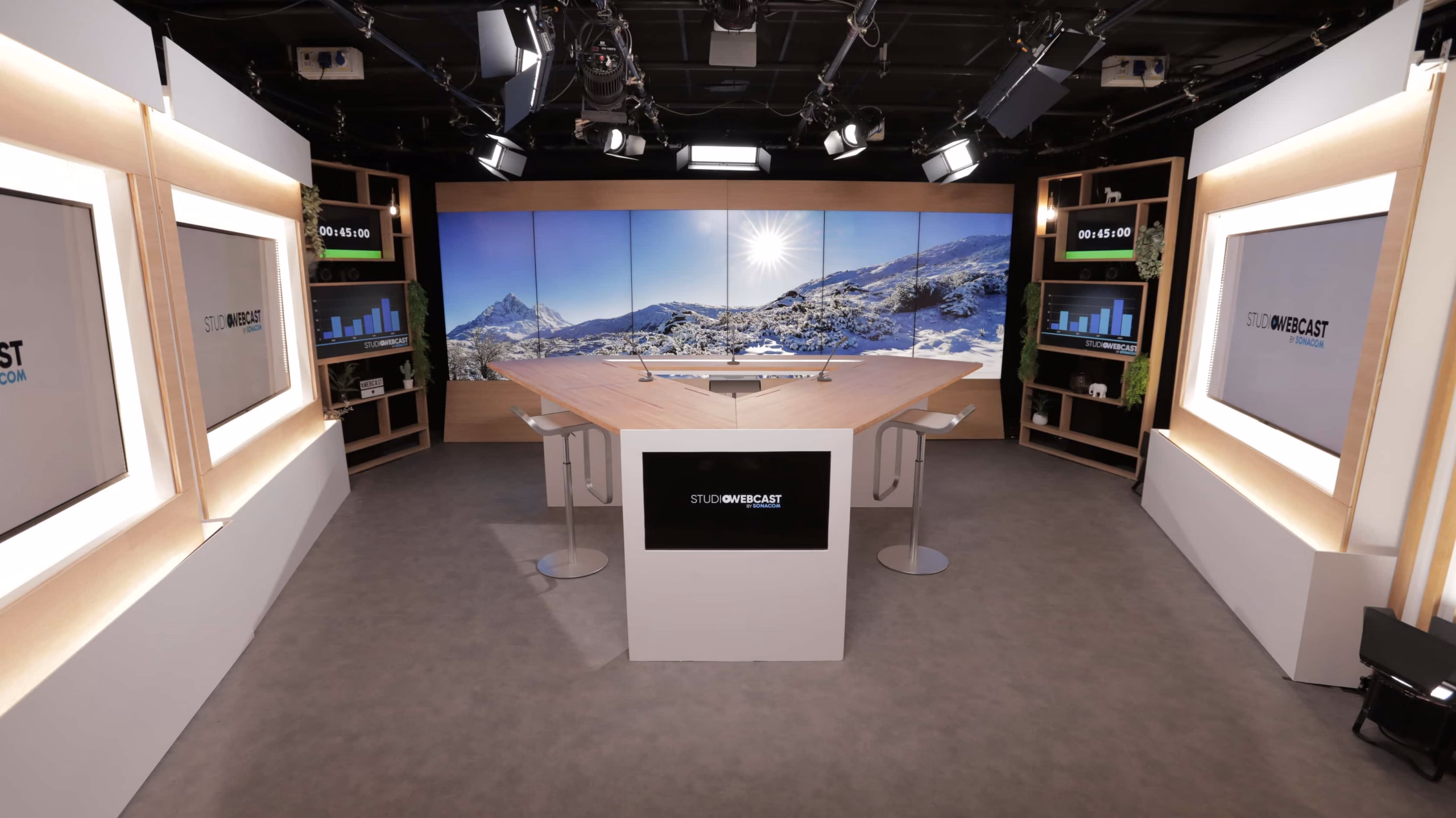 Vue d'ensemble du plateau TV du Studio Webcast avec fond de décor montagne enneigée sur écran LED et éclairage professionnel